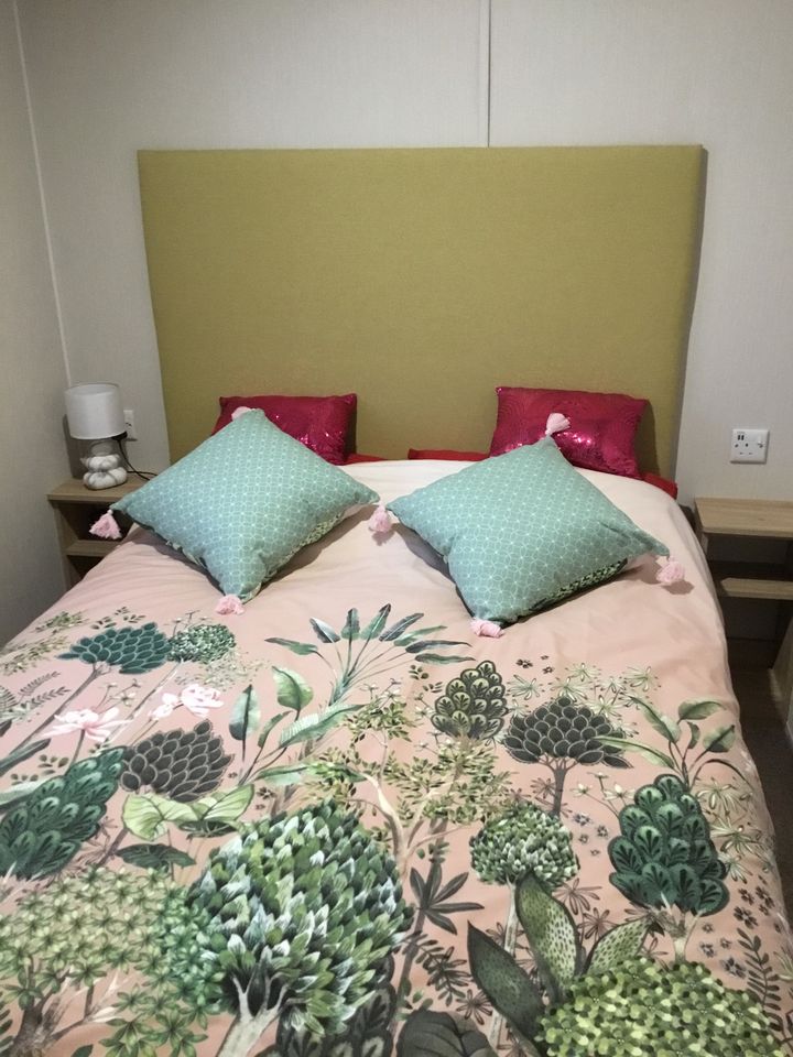 The double bedroom, with a floral duvet and green cushions